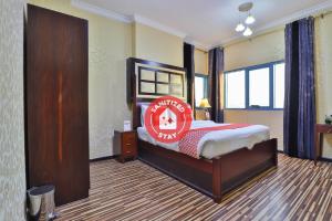 a bedroom with a bed with a sign on it at Grand PJ Hotel - Free Parking in Ras al Khaimah