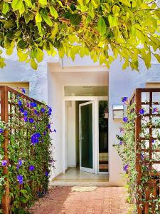 une maison blanche avec une porte et des fleurs violettes dans l'établissement Le cocon de Sfax, à Sfax
