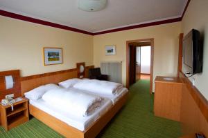 a bedroom with a large bed and a flat screen tv at Gasthof Böhm in Persenbeug