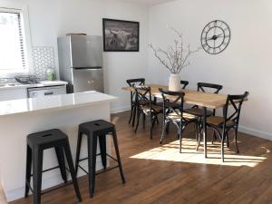 una cocina con mesa de madera y taburetes negros en Oak Lane Guest House & Farm Stay, en Whorouly