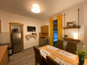 eine Küche und ein Esszimmer mit einem Tisch und einem Kühlschrank in der Unterkunft FeWo Nietleben in Halle an der Saale