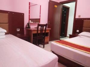 ein Hotelzimmer mit 2 Betten und einem Schreibtisch mit einem Spiegel in der Unterkunft Xi'an Helen Apartment in Xi'an
