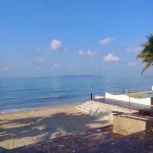 a beach with a palm tree and the ocean at Pool Villa PB6rayong in Rayong