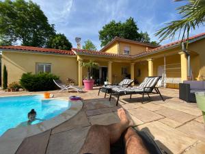 un hombre tirado en el suelo junto a una piscina en Chambres dans villa avec piscine, en Gleizé