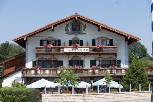 a building with a balcony with umbrellas in front of it at Hotel Gasthof Neuwirt in Holzkirchen