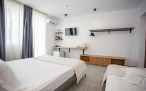 a hotel room with two beds and a television at Hotel Mistral in Nesebar