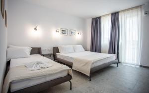 a hotel room with two beds and a window at Hotel Mistral in Nesebar
