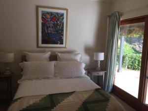 een bed met witte kussens en een foto aan de muur bij Tantallon in Berry