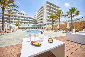 een tafel met fruit erop naast een zwembad bij Hotel Playa Golf in Playa de Palma