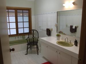 a bathroom with a sink and a chair and a mirror at Tantallon in Berry