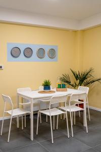 una mesa y sillas blancas en una habitación con una pared amarilla en Kostovski Rooms-near E75 to Greece, en Veles