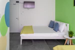 a white bed with blue pillows in a room at Kostovski Rooms-near E75 to Greece in Veles