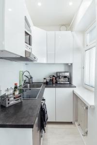 ヘルシンキにあるSailor`s Apartmentの白いキッチン(白いキャビネット、シンク付)