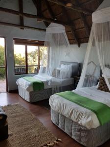 a bedroom with two beds with mosquito nets at Camp Acacia in Paterson