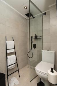 a bathroom with a toilet and a glass shower at Park Hotel in Alexandroupoli
