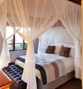 a bedroom with a canopy bed with curtains at Camp Acacia in Paterson