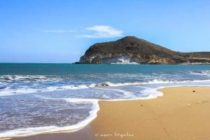 una playa de arena con una montaña en el fondo en ZARATUSTRA. Rodalquilar CENTRO. GRAN terra. WIFI, en Rodalquilar