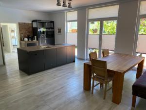 eine Küche und ein Esszimmer mit einem Holztisch in der Unterkunft Gästehaus Schewe in Ahnsen