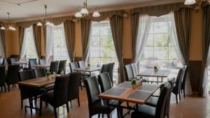 a restaurant with tables and chairs and windows at Villa Tatiana Verhneozernaya in Kaliningrad