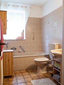 a bathroom with a tub and a toilet and a sink at Ferienhaus Waldidyll in Lemgo