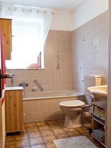 a bathroom with a tub and a toilet and a sink at Ferienhaus Waldidyll in Lemgo +12 photos