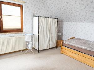 ein Schlafzimmer mit einem Bett, einem Fenster und einem Heizkörper in der Unterkunft Ferienhaus Waldidyll in Lemgo