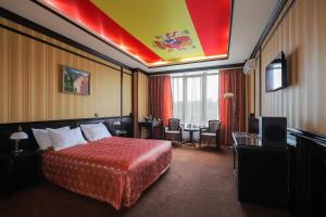 Attache Hotel في كييف: غرفة فندقية بسرير وطاولة وكراسي