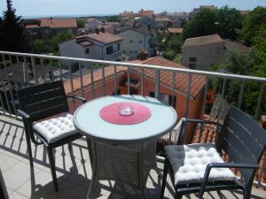 a table and chairs on a balcony with a view at Apartment Mamut in Premantura