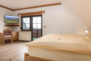 a bedroom with a large bed and a large window at Hotel-Restaurant Haus Berkenbaum in Kierspe