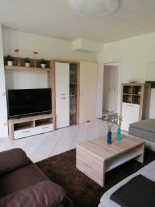 ein Wohnzimmer mit einem TV und einem Couchtisch in der Unterkunft FEWO-ATLANTA Reinhardshausen in Reinhardshausen