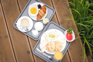 two trays of breakfast food on a wooden table at Bezpieczna Przystań - Apartamenty-balia, sauna, narty in Uherce Mineralne (7)