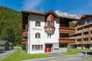 a hotel with a balcony on the side of a building at Montela Hotel & Resort - Haus Antares in Saas-Grund