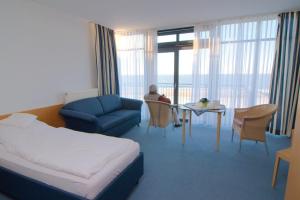 ein Hotelzimmer mit einem Bett, einer Couch und einem Tisch in der Unterkunft Gästehaus Germania in Wangerooge