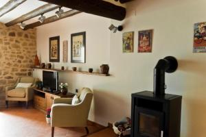 a living room with a fireplace and a tv at Casa Carmela in Calaceite +2 photos