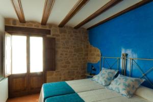 a blue bedroom with a bed and a window at Casa Carmela in Calaceite