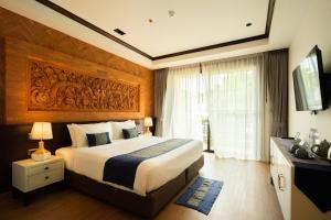 a hotel room with a bed and a television at Phor Liang Meun Terracotta Arts in Chiang Mai