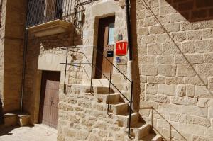 a brick building with a staircase next to a door at Casa Carmela in Calaceite