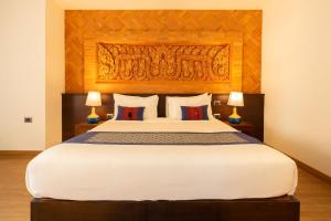 a bedroom with a large bed with a wooden headboard at Phor Liang Meun Terracotta Arts in Chiang Mai