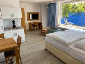 ein Schlafzimmer mit einem Bett und einem Tisch sowie eine Küche in der Unterkunft Gästehaus Schewe in Ahnsen