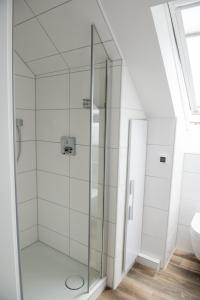 a glass shower in a bathroom with a toilet at Stadtoase in Bremerhaven