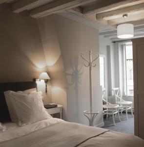 a bedroom with a bed and a table and chairs at Hôtel La Licorne & Spa in Lyons-la-Forêt