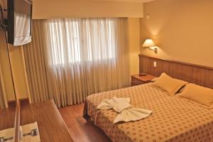 コルドバにあるHotel Felipe IIのベッドと窓のあるホテルの部屋