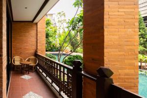 a balcony with a table and chairs and a pool at Phor Liang Meun Terracotta Arts in Chiang Mai