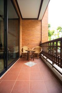 a patio with a table and chairs on a balcony at Phor Liang Meun Terracotta Arts in Chiang Mai