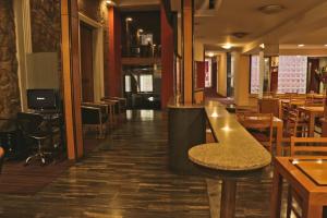 a restaurant with a bar and tables and chairs at Hotel Felipe II in Cordoba