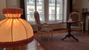 un soggiorno con tavolo, sedie e lampada di La Maison Serrurier - Chambres d’hôtes a Morlaix