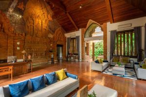 a large living room with a couch and a tv at Phor Liang Meun Terracotta Arts in Chiang Mai