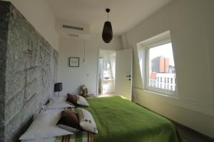 1 dormitorio con cama verde y ventana en The Soul Antwerp en Amberes