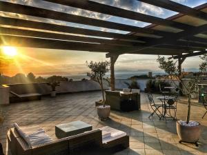 patio z kanapami i widokiem na zachód słońca w obiekcie Residenza Cunto w mieście Castellabate