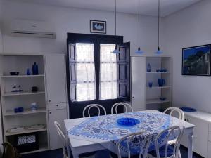 una sala da pranzo con tavolo, sedie e finestra di Esclusiva a Favignana